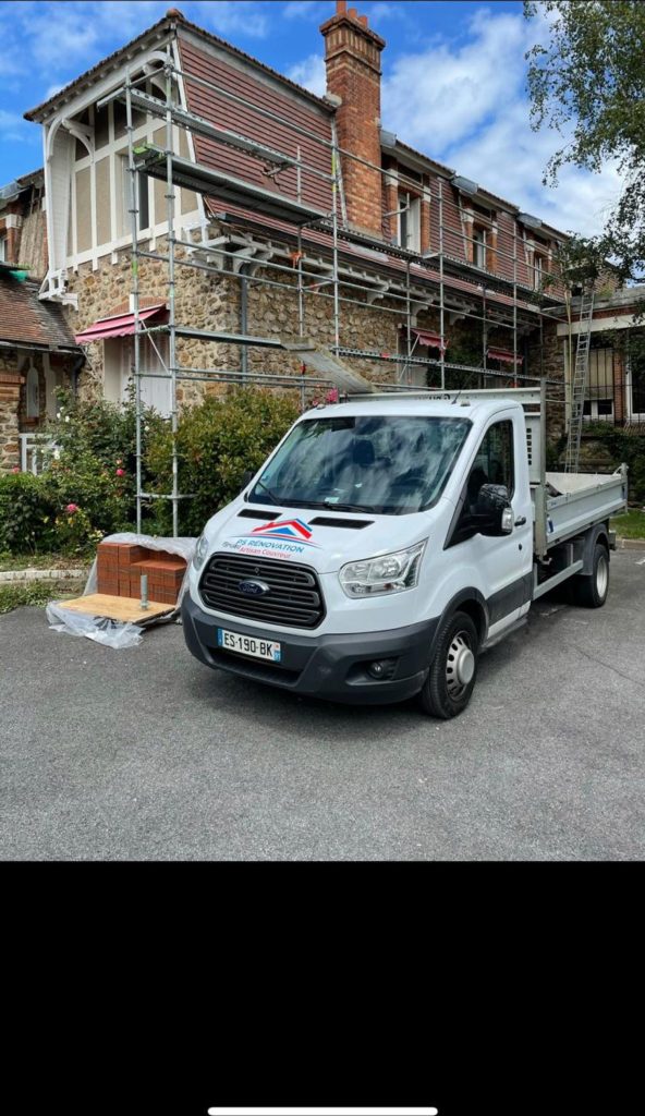 Camion benne siglé PS Rénovation Artisan Couvreur devant un chantier