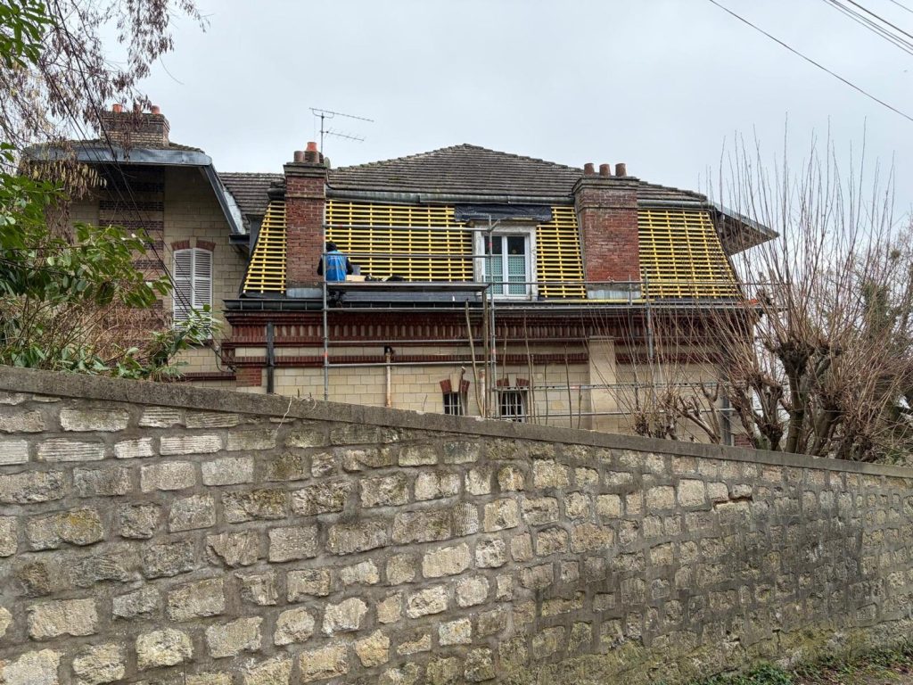 Liteaunage neuf autour d’une lucarne sur une maison en brique