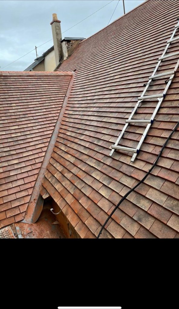 Toiture en tuiles plates terminée, avec échelle de couvreur
